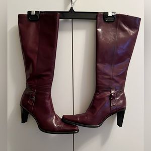 Burgundy leather knee high boots.